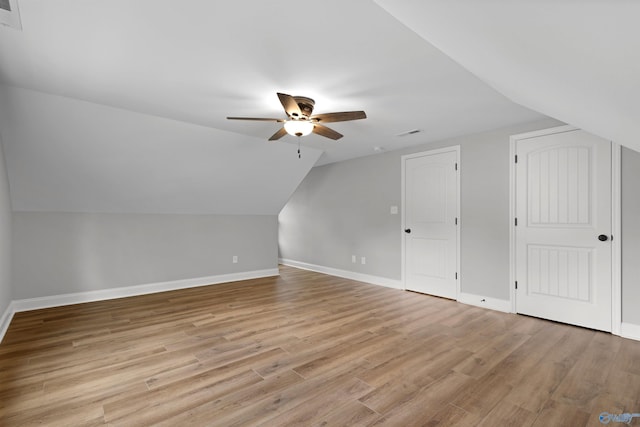 bonus room featuring a ceiling fan, baseboards, light wood-type flooring, and lofted ceiling