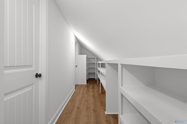 additional living space featuring vaulted ceiling and wood finished floors