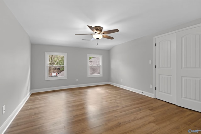 spare room with ceiling fan, wood finished floors, and baseboards