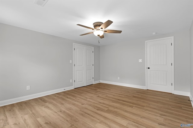 empty room featuring ceiling fan, light wood-type flooring, and baseboards