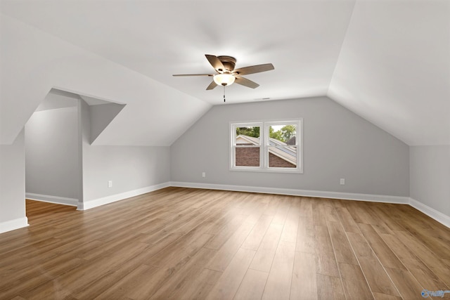additional living space with a ceiling fan, vaulted ceiling, wood finished floors, and baseboards