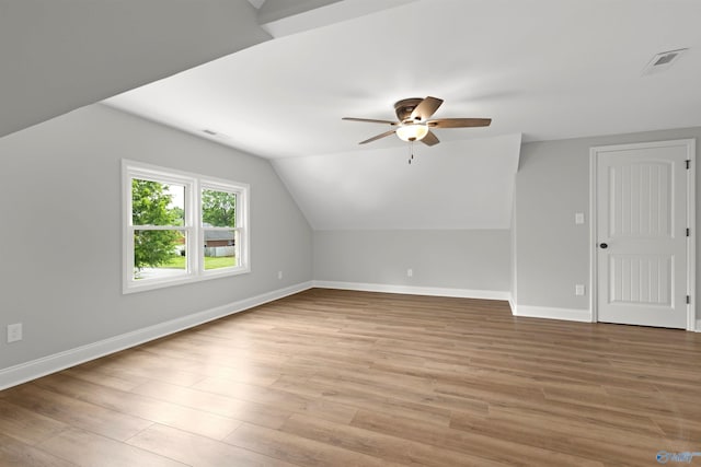 bonus room with a ceiling fan, baseboards, light wood-style flooring, and lofted ceiling
