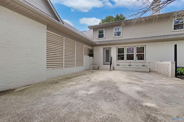 property entrance featuring a patio area and brick siding