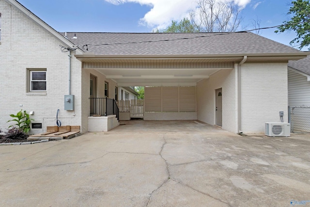rear view of house featuring brick siding, roof with shingles, and an attached carport