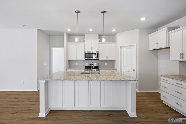 177 Pennington Ave, Huntsville, AL 35811 - kitchen featuring stainless steel appliances, white cabinetry, an island with sink, tasteful backsplash, and dark wood finished floors