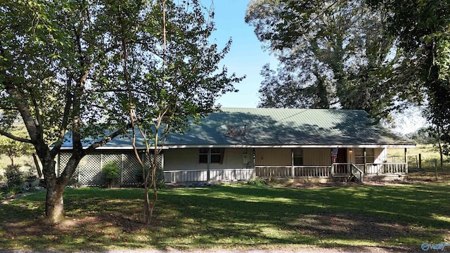 rear view of house featuring a porch and a yard