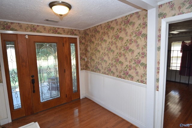 foyer entrance featuring ornamental molding, hardwood / wood-style flooring, and a textured ceiling