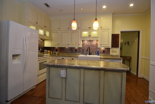 kitchen with sink, white appliances, a center island, and dark hardwood / wood-style flooring