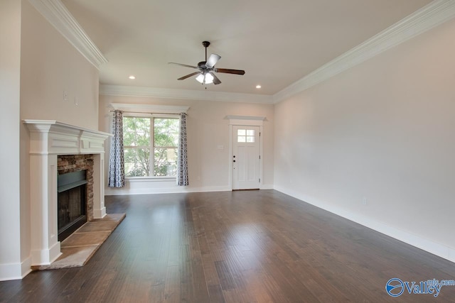 unfurnished living room featuring a fireplace, dark hardwood / wood-style flooring, ceiling fan, and crown molding