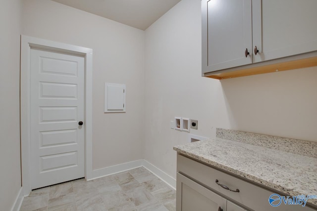 clothes washing area with cabinets, electric dryer hookup, and washer hookup