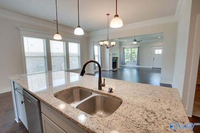 kitchen with dark hardwood / wood-style flooring, dishwasher, hanging light fixtures, sink, and light stone countertops