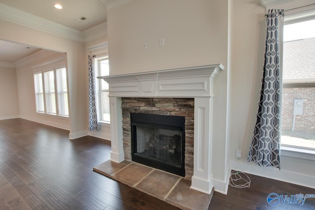 interior space with hardwood / wood-style flooring, a stone fireplace, and ornamental molding