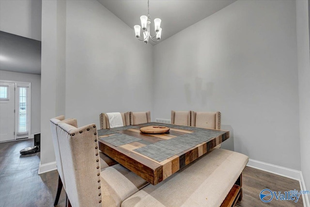 dining space featuring dark wood-style floors, baseboards, an inviting chandelier, and vaulted ceiling