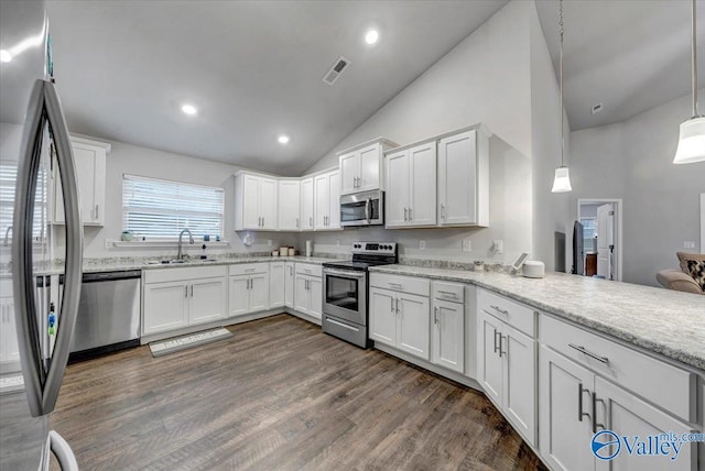 kitchen featuring visible vents, dark wood-type flooring, appliances with stainless steel finishes, white cabinetry, and a sink