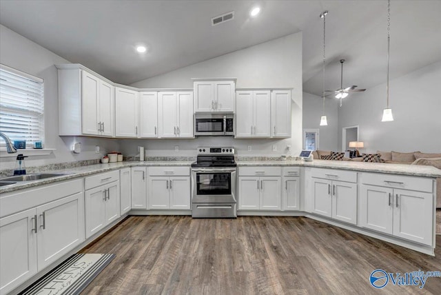 kitchen featuring visible vents, a peninsula, a sink, stainless steel appliances, and white cabinets