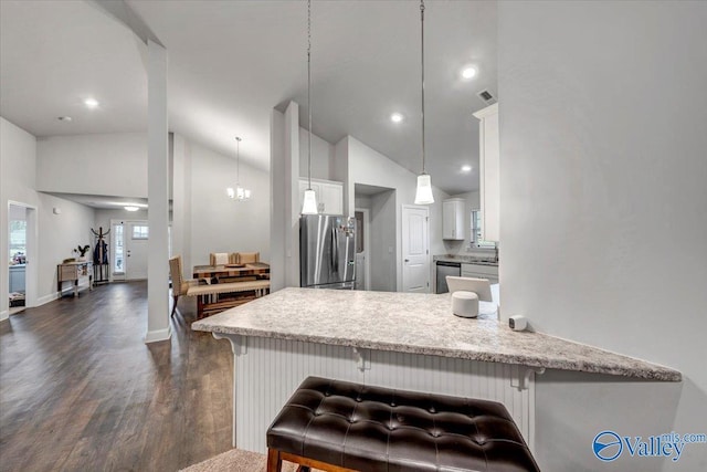 kitchen featuring dark wood-type flooring, appliances with stainless steel finishes, a peninsula, white cabinets, and high vaulted ceiling