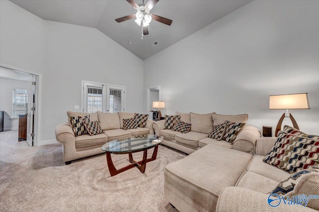 living area featuring visible vents, high vaulted ceiling, baseboards, light colored carpet, and ceiling fan