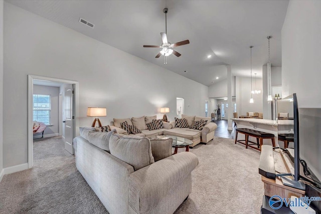 carpeted living area featuring baseboards, visible vents, high vaulted ceiling, and a ceiling fan