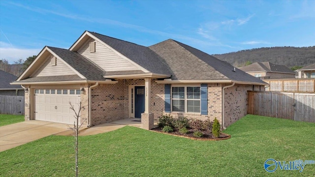 view of front of home featuring a garage, a front lawn, driveway, and fence