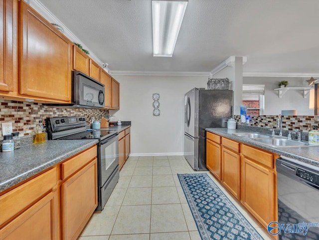 kitchen with ornamental molding, black appliances, a sink, dark countertops, and decorative backsplash