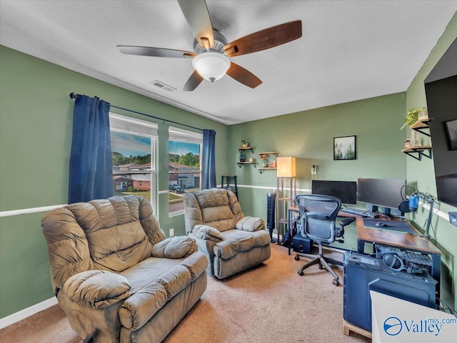 carpeted office space with visible vents, baseboards, a ceiling fan, and a textured ceiling