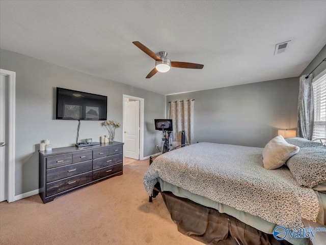 bedroom featuring baseboards, visible vents, light colored carpet, and a ceiling fan