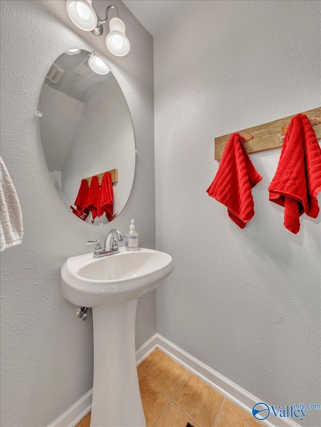 bathroom with baseboards and tile patterned flooring