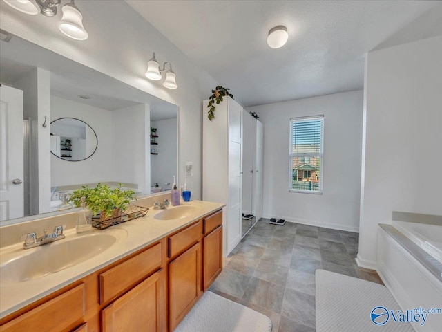 bathroom with a sink, a tub to relax in, baseboards, and double vanity