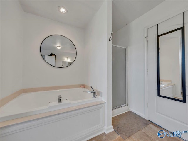 full bathroom featuring a bath and a shower stall