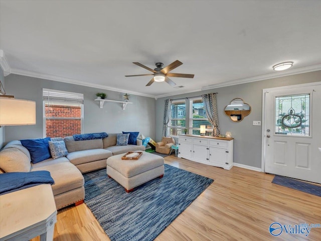 living room with baseboards, light wood-type flooring, ornamental molding, visible vents, and ceiling fan