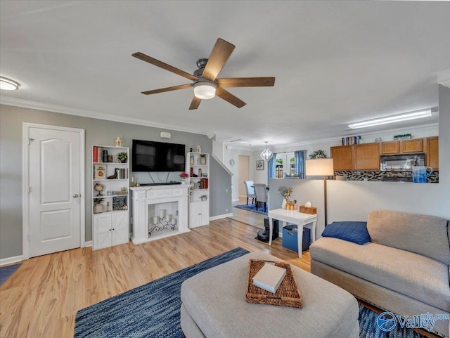 living area with light wood-style flooring, crown molding, and ceiling fan
