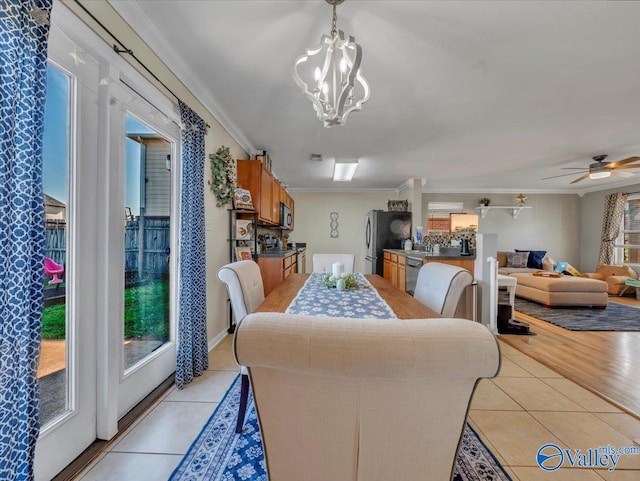 dining room featuring crown molding, light tile patterned floors, and ceiling fan with notable chandelier