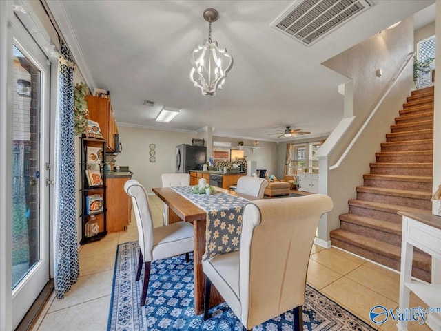 dining area with ceiling fan with notable chandelier, ornamental molding, visible vents, light tile patterned flooring, and stairs