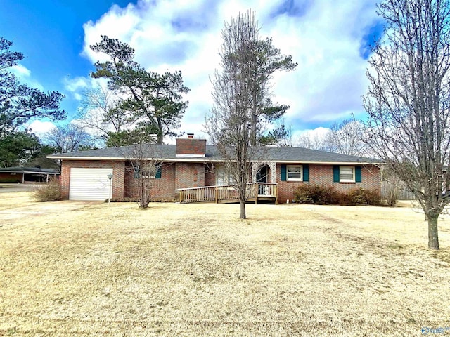 single story home featuring a garage, a deck, and a front lawn