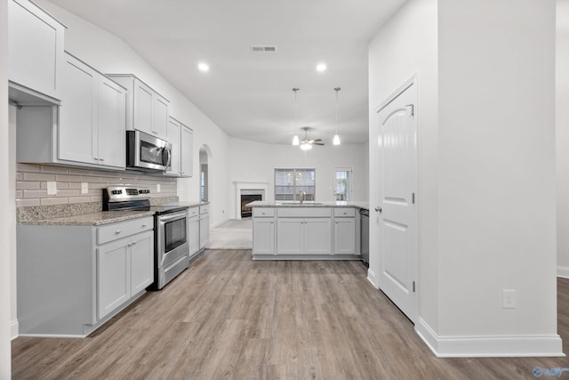 kitchen featuring visible vents, a sink, light wood finished floors, and appliances with stainless steel finishes