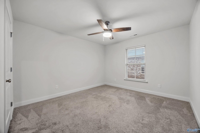 spare room with carpet floors, a ceiling fan, baseboards, and visible vents