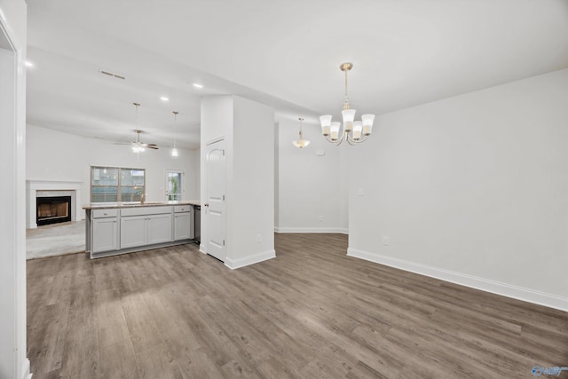 unfurnished living room with a fireplace, recessed lighting, baseboards, wood finished floors, and visible vents