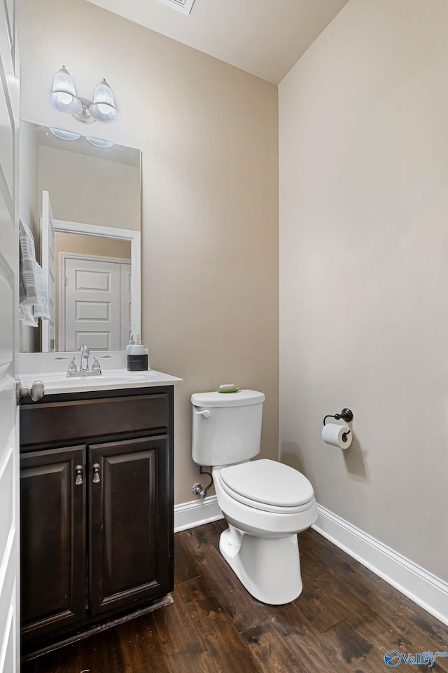 bathroom featuring wood-type flooring, toilet, and vanity