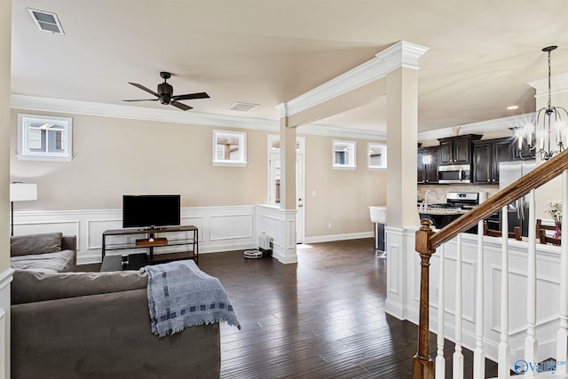 living room featuring crown molding, dark hardwood / wood-style floors, and ceiling fan with notable chandelier