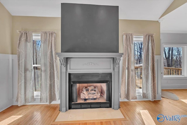 interior details with a fireplace with flush hearth and wood finished floors