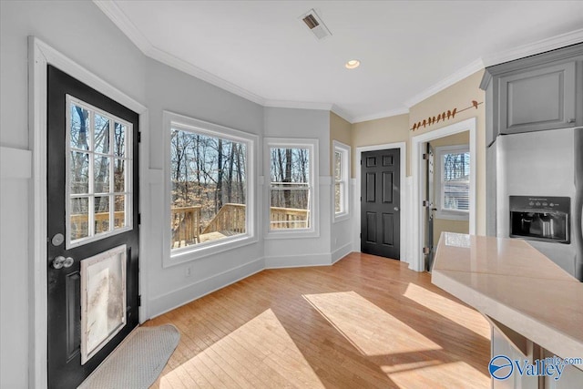 entryway featuring crown molding, light wood finished floors, baseboards, visible vents, and recessed lighting