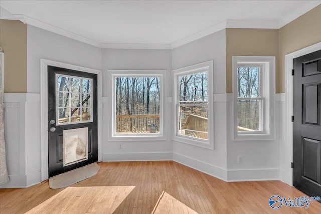 foyer with baseboards, light wood-style flooring, and ornamental molding