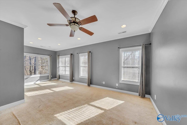 interior space with baseboards, a wealth of natural light, visible vents, and crown molding
