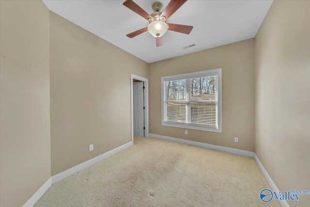 unfurnished room featuring baseboards, visible vents, a ceiling fan, and light colored carpet