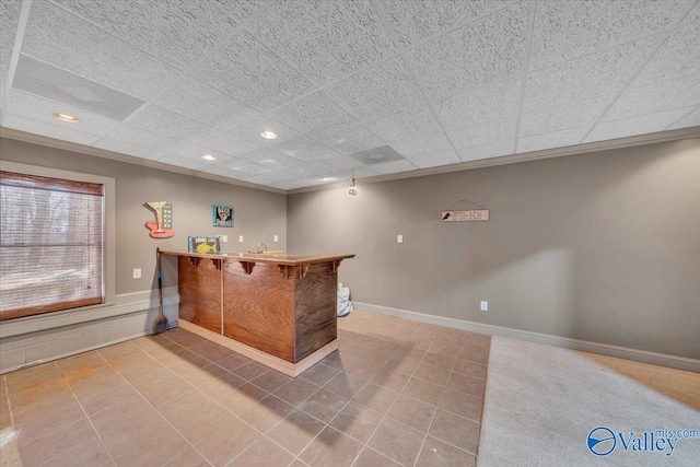 bar featuring bar area, recessed lighting, tile patterned flooring, baseboards, and ornamental molding