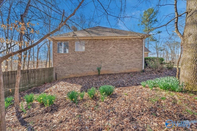 view of home's exterior featuring fence and brick siding