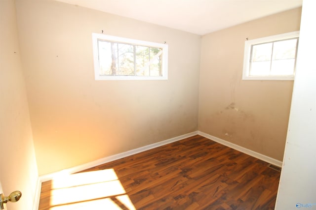 unfurnished room with plenty of natural light and dark wood-type flooring