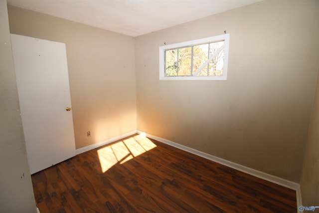 unfurnished room with dark hardwood / wood-style floors