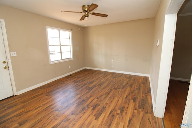 spare room featuring dark wood-type flooring and ceiling fan