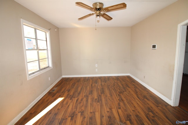 spare room with dark wood-type flooring, ceiling fan, and a wealth of natural light